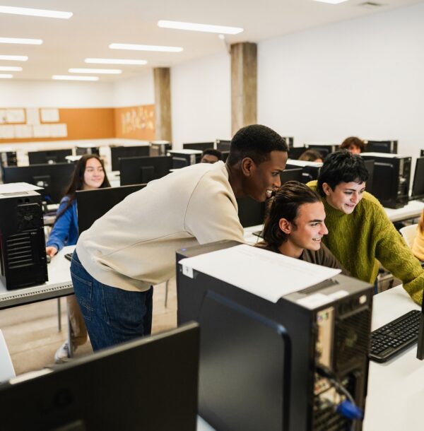 Young multiracial students using computers during business class at school