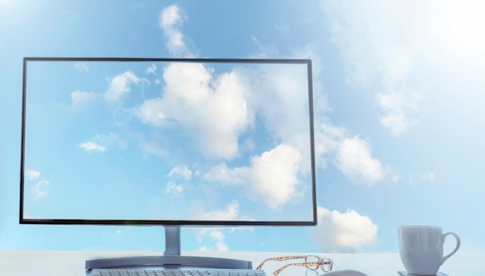 Office in the sky, cloud computing concept. Desktop with keyboard, mouse and coffee.